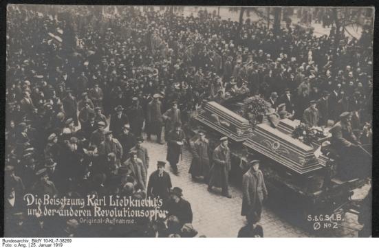 Originaltitel:Trauerzug am 25.Januar 1919 in Berlin zur Beisetzung Karl Liebknechts und der im Januar gefallenen Rvolutionäre. [Text auf Vorderseite: Die Beisetzung Karl Liebknecht's und der anderen Rvolutionsopfer - Originalaufnahme, S.&G.S.i.B. No. 2 Archivtitel:Berlin.- Trauerzug zur Beisetzung von Karl Liebknecht Datierung:25. Januar 1919 Fotograf:o.Ang. Quelle:Bundesarchiv (SAPMO)